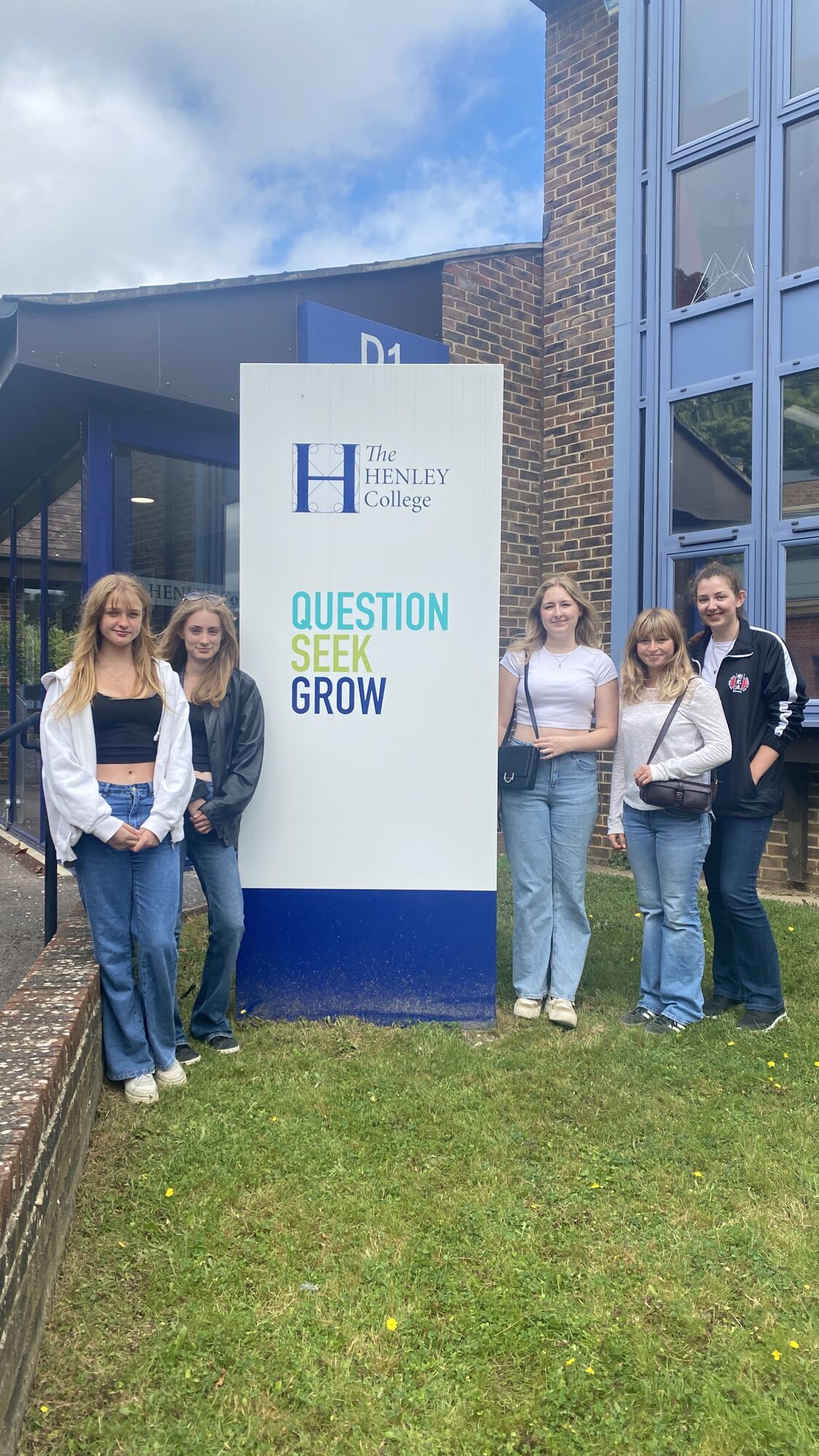 Group of girls around QSG sign